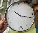 Reloj de pared y plateado fondo crema