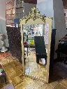 Espejo biselado de gran tamaño, marco en madera color dorado, bordes en madera tallada.